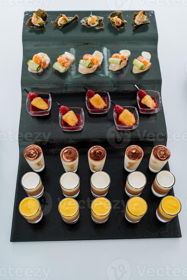 Catering in the office, trifles in a glass, liquid cake in cups top view, beautiful serving of treats to the festive table. photo