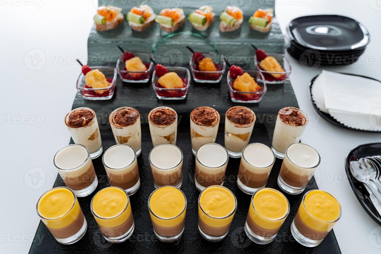 Trifles in a glass, Liquid cake in cups. A delicious set of desserts for the holiday, colorful treats, setting a sweet table, a beautiful presentation of the dish. photo