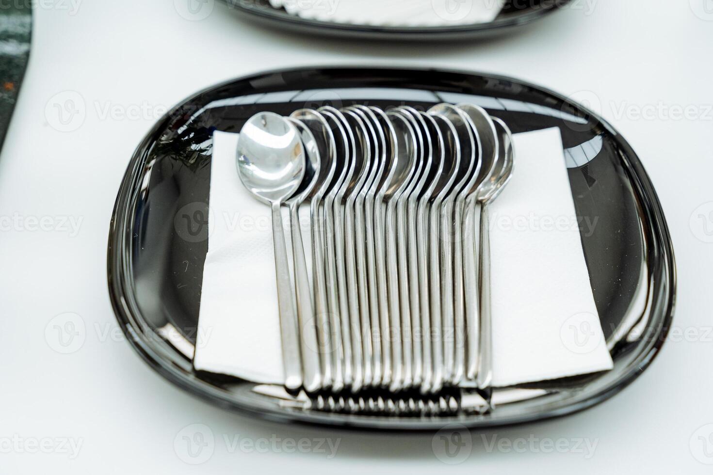 A set of teaspoons lying on a serving plate, metal kitchen appliances, a small spoon, breakfast at the hotel. photo