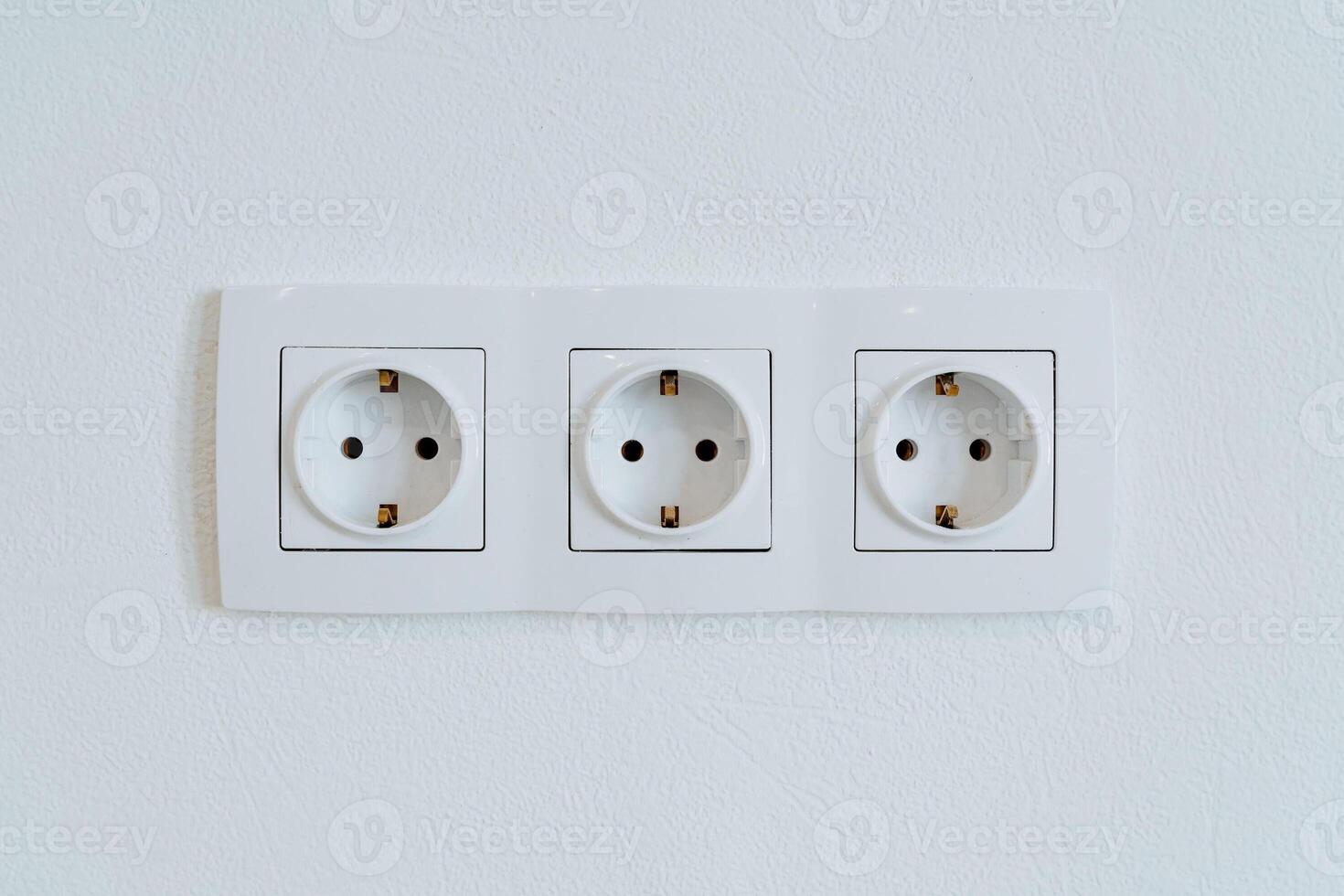 Three sockets in the wall are shot close-up, the power output in the home room. photo