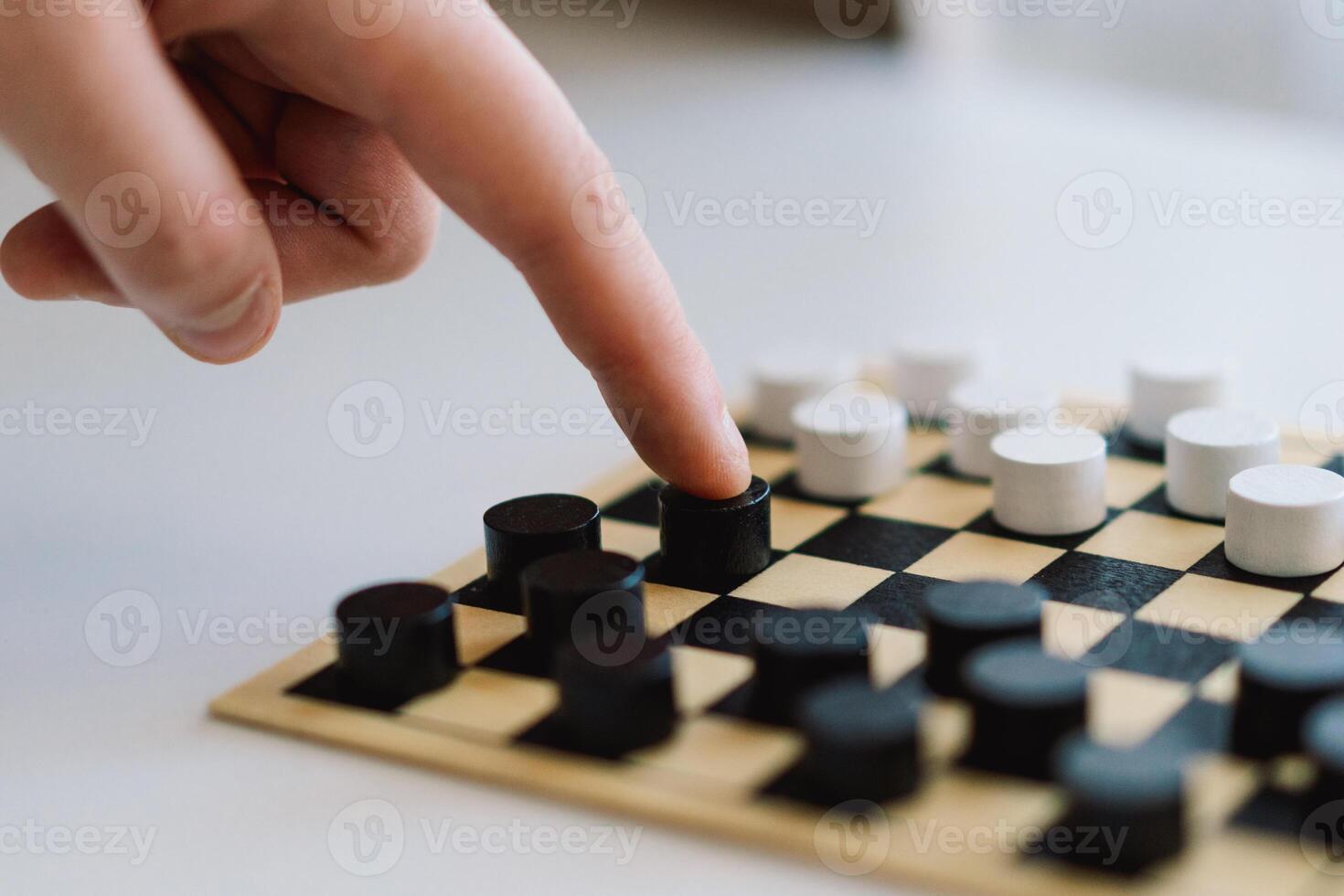 Teenage Girl and Boy Playing Board Game checkers In Living Room photo