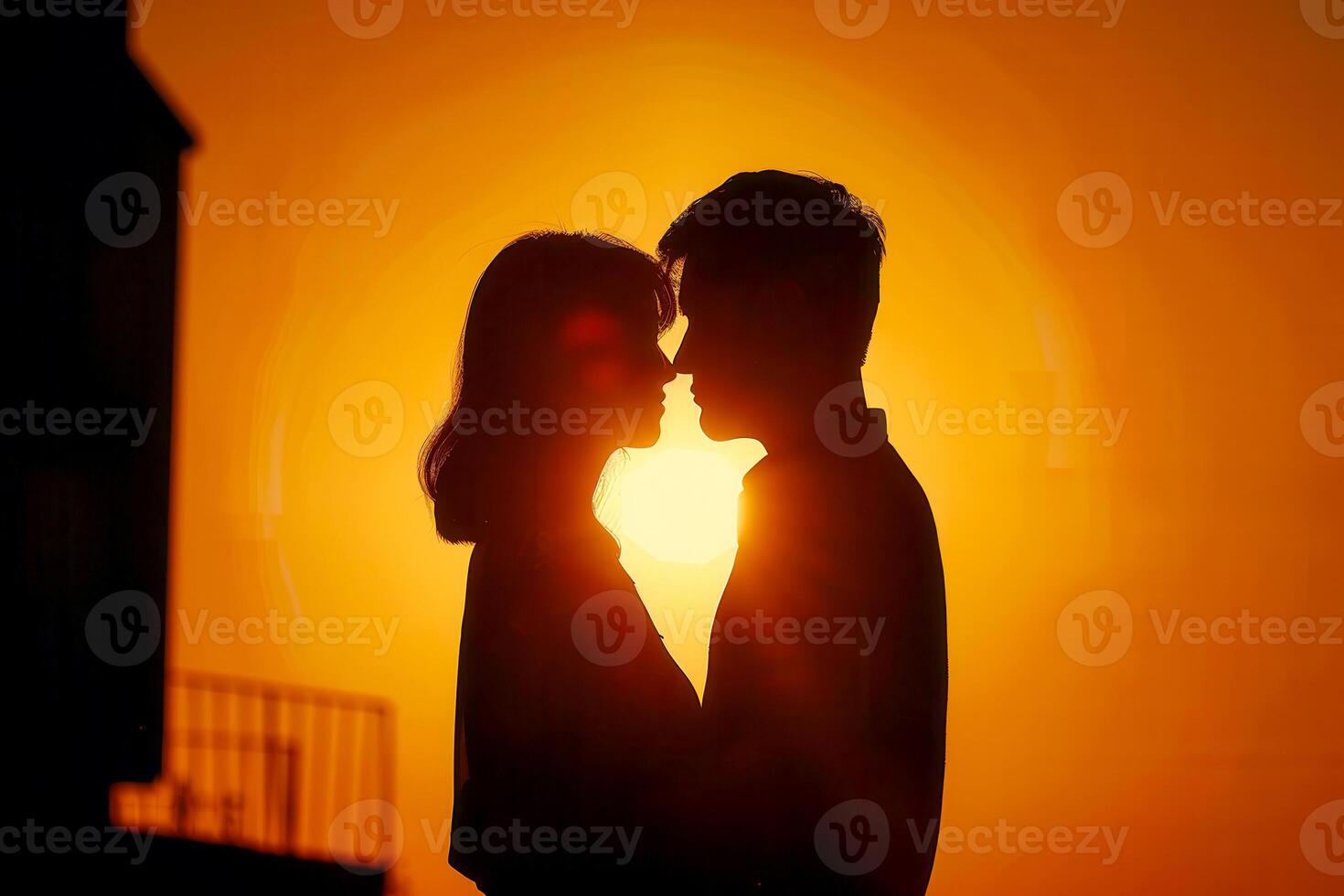 A couple is kissing in front of a sunset photo