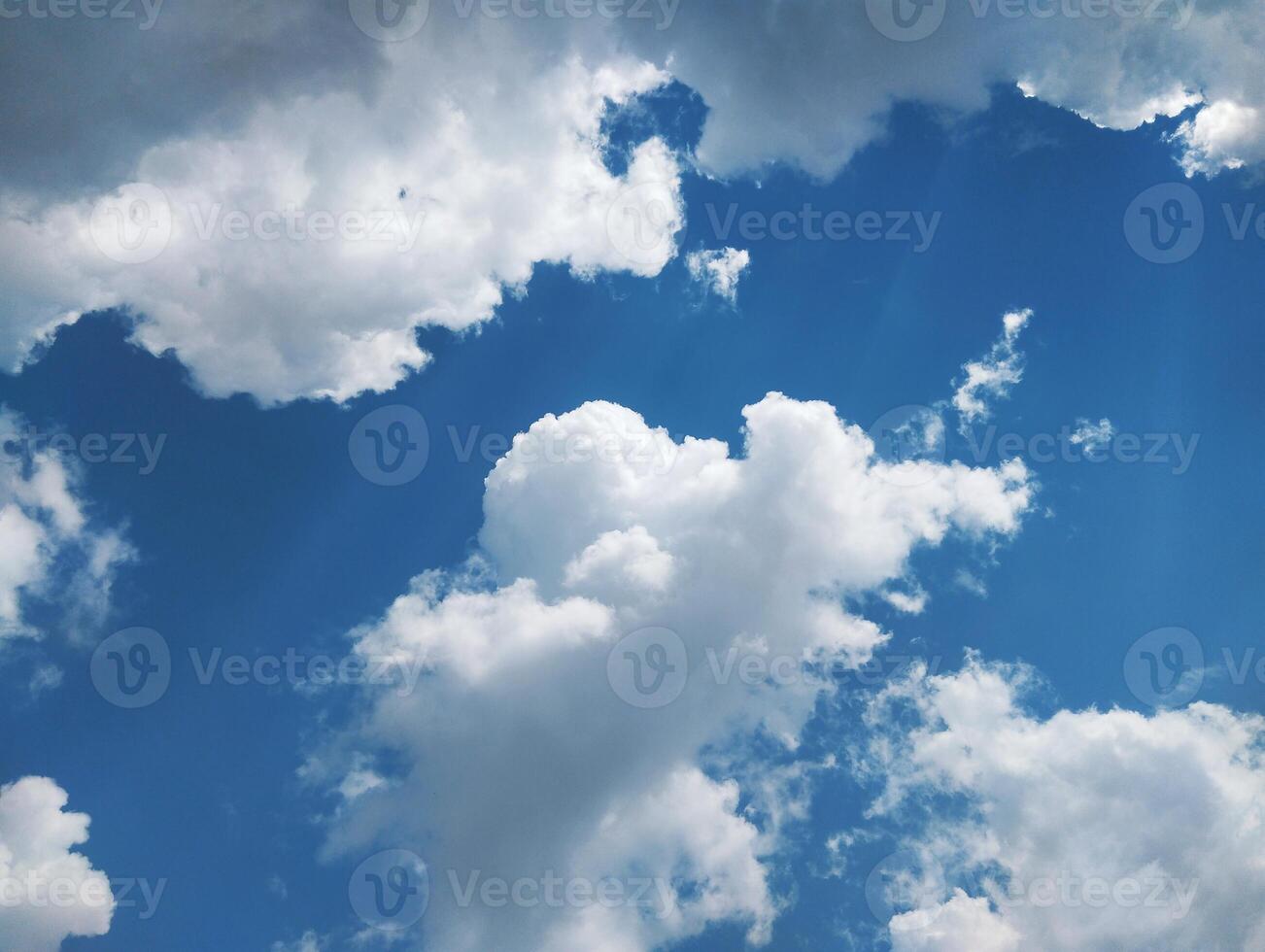 clouds in the sky with sun rays shining through photo