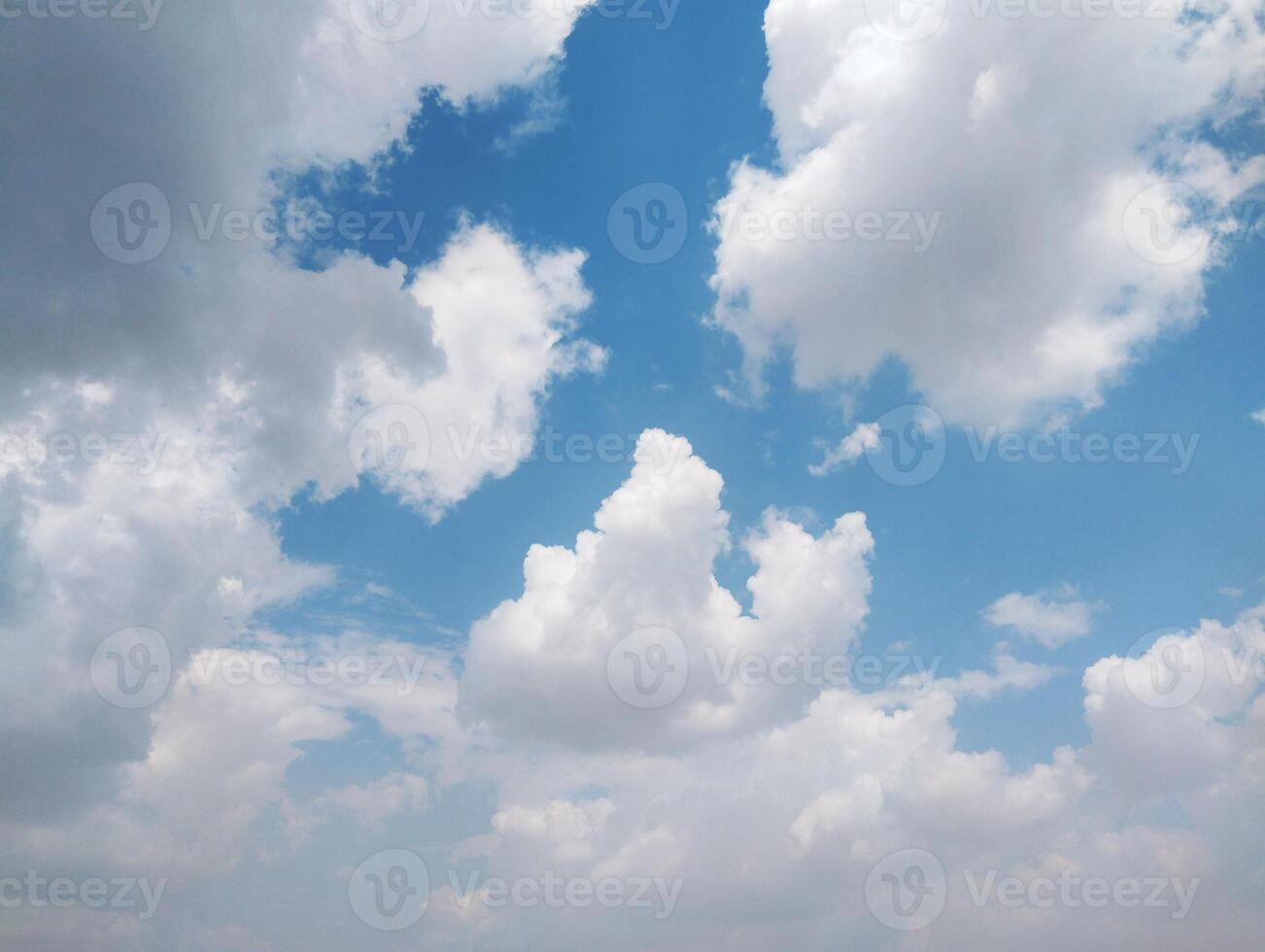 a large field with a blue sky and some clouds photo