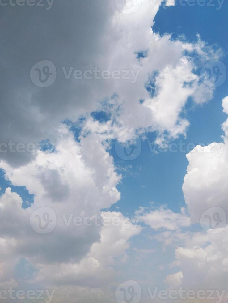 a large field with a blue sky and clouds photo