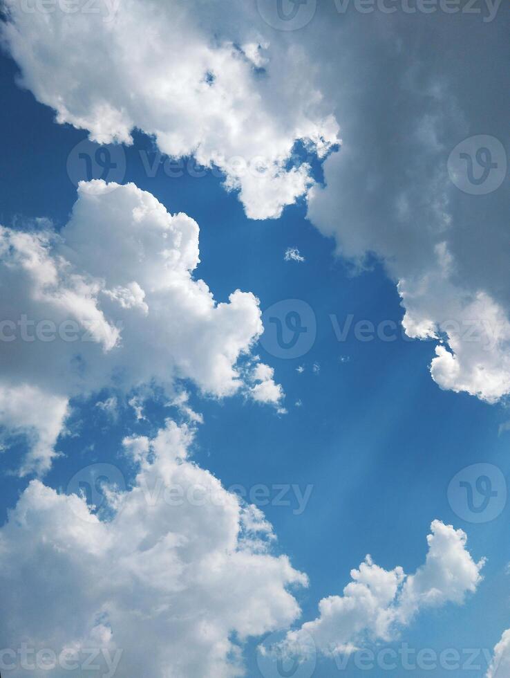 clouds in the sky with sun rays shining through photo