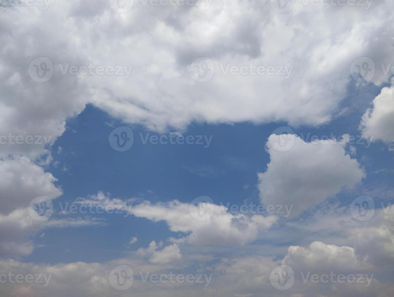 a large field with a blue sky and clouds photo