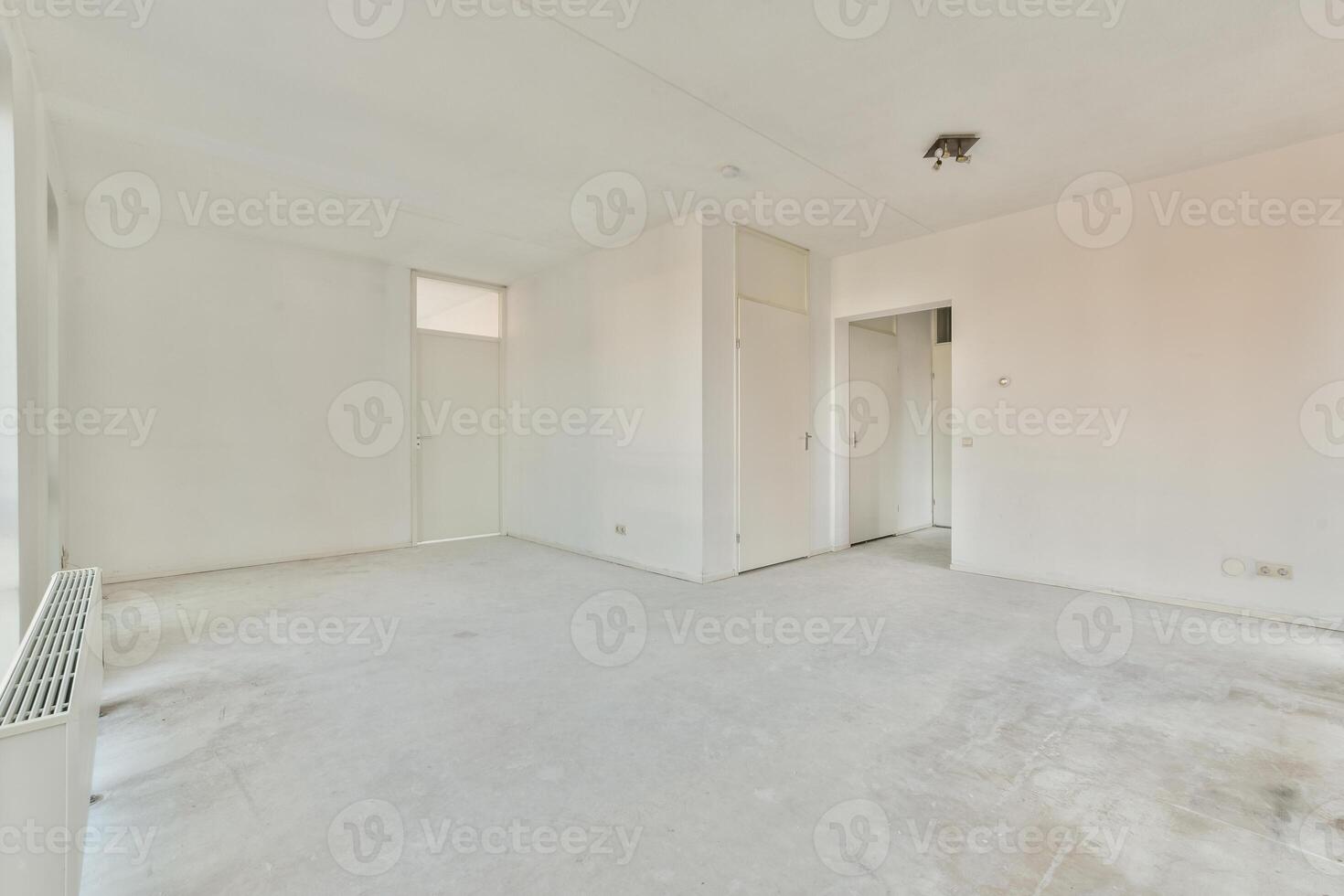 An empty room with white walls and a radiator photo