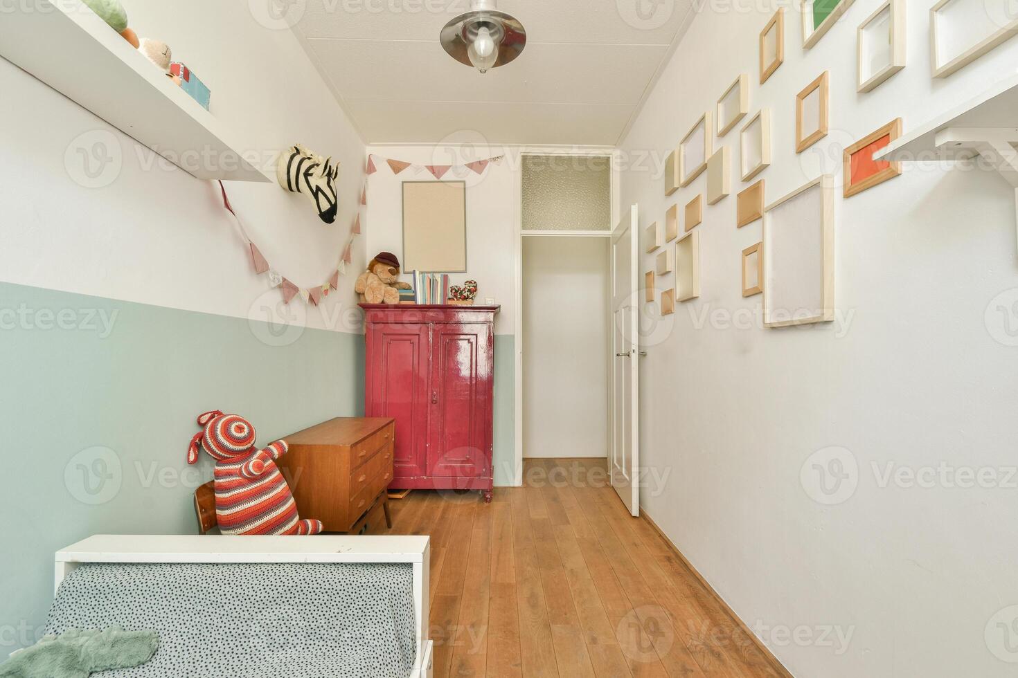 A small hallway with a bed, a dresser and a toy photo