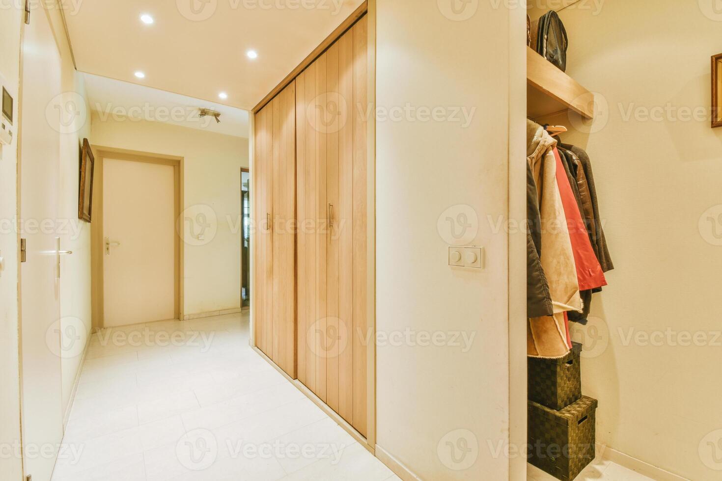 A hallway with a wooden closet and a coat rack photo