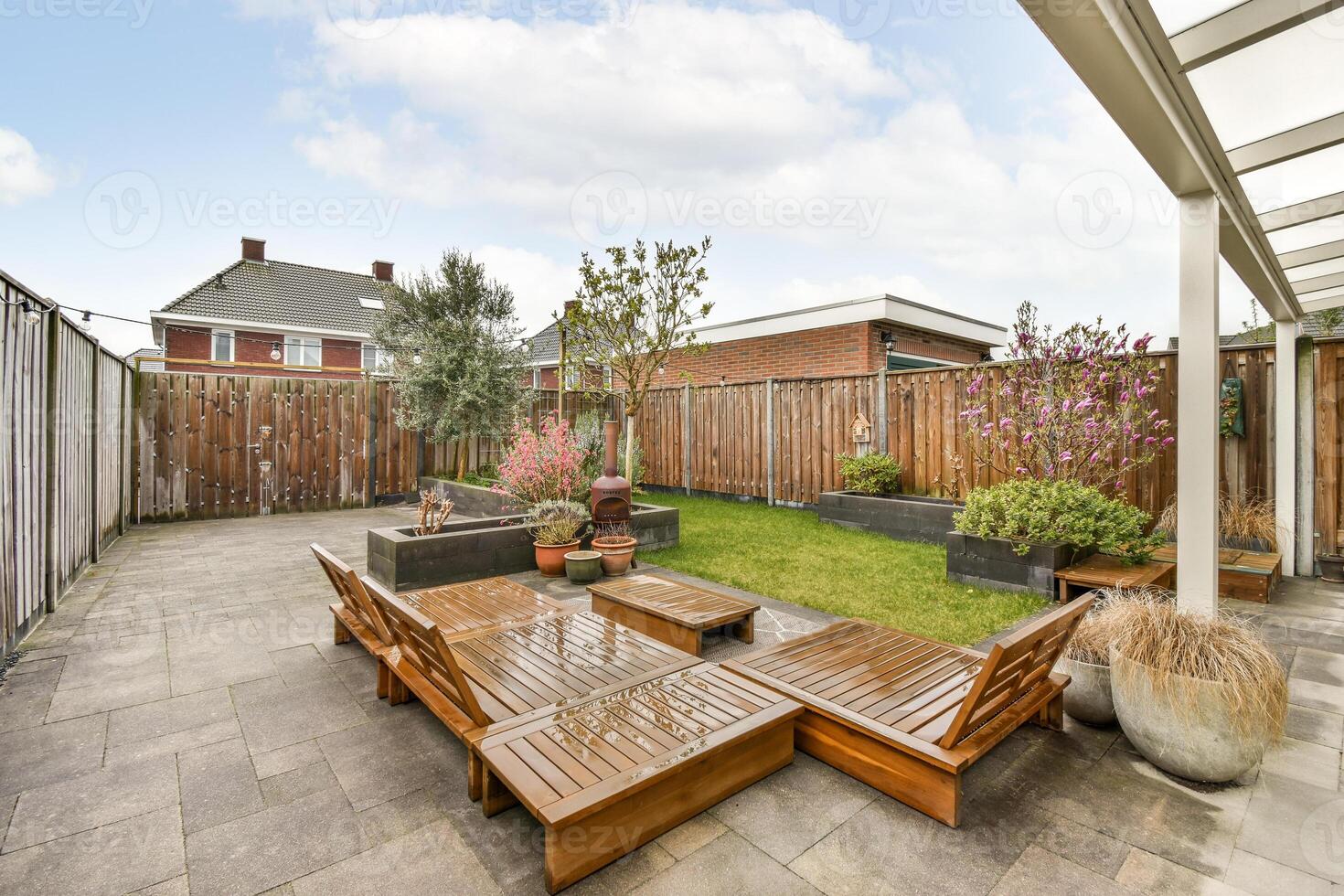 A backyard with a patio and wooden furniture photo