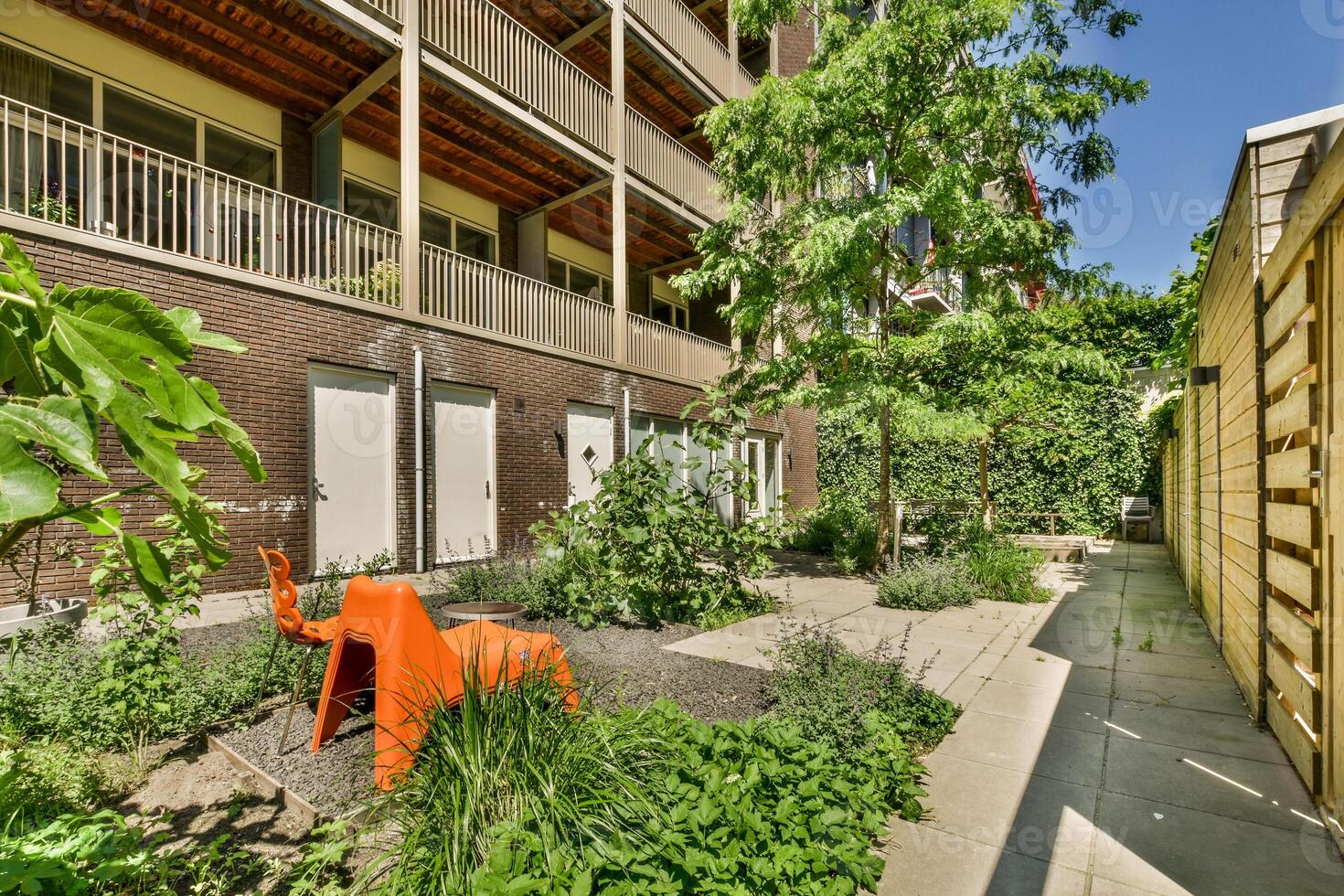 A courtyard with a garden and a bench photo