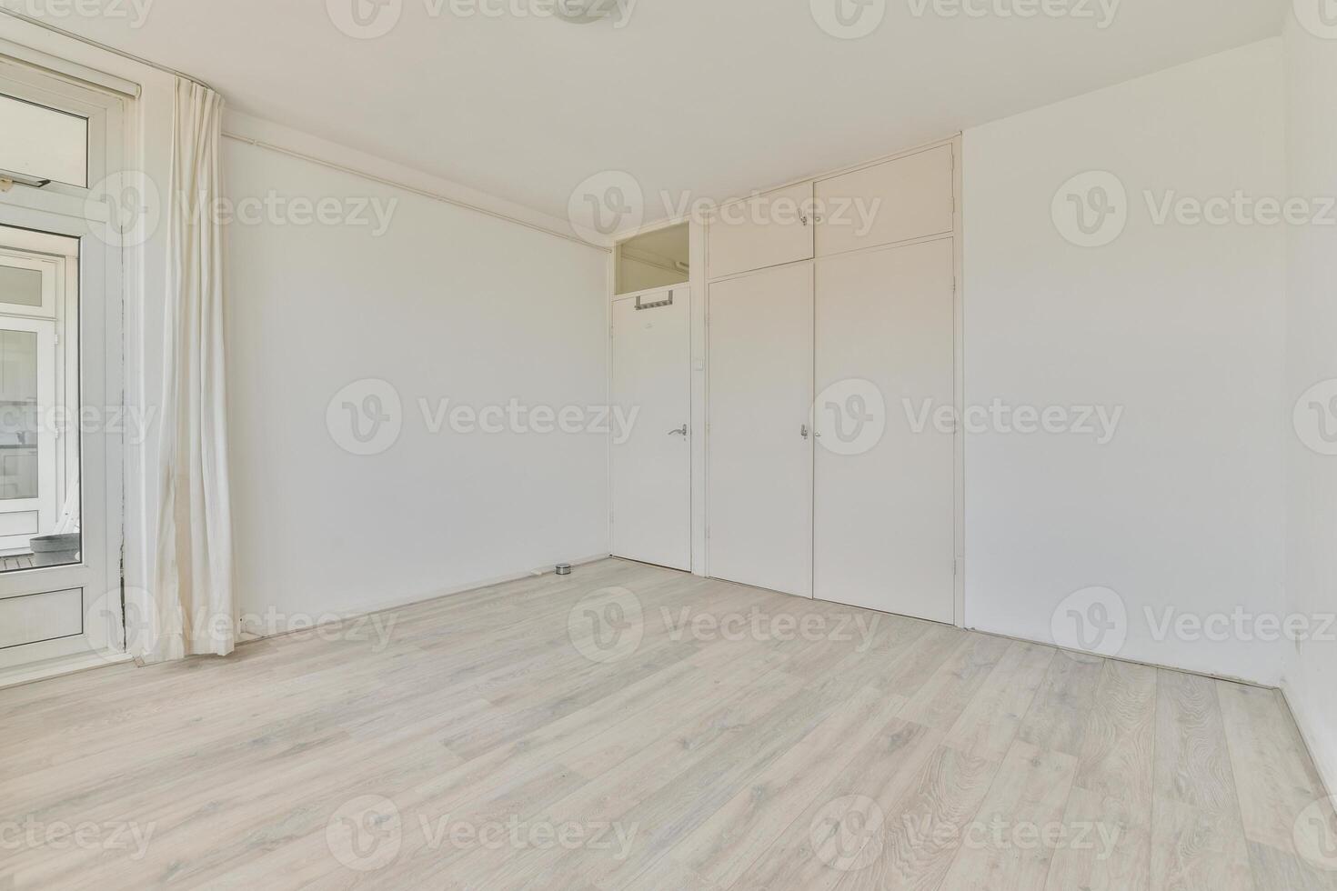 An empty room with white walls and wooden floors photo