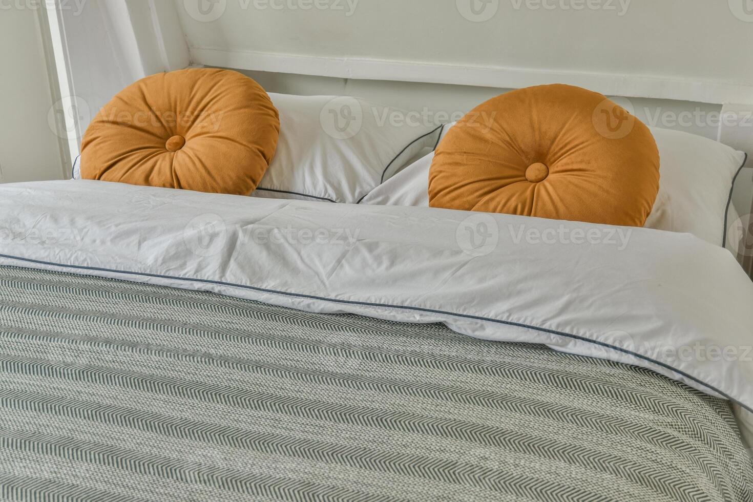 A bed with two orange pillows on it photo