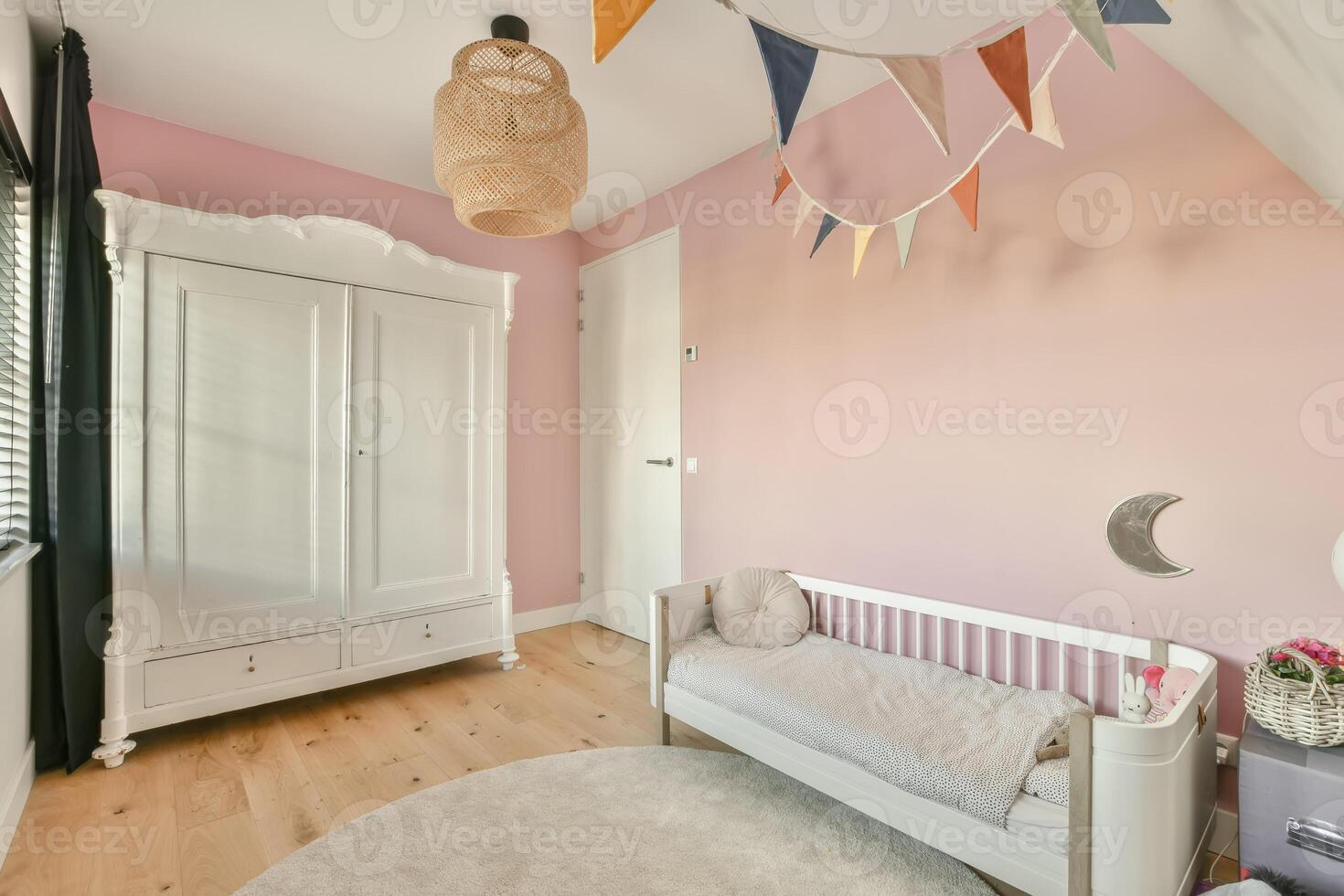A baby's room with pink walls and wooden floors photo