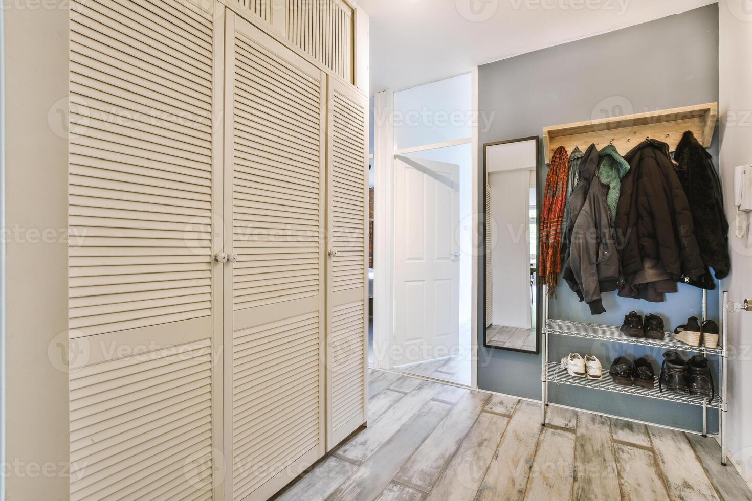 A hallway with a closet and coat rack photo