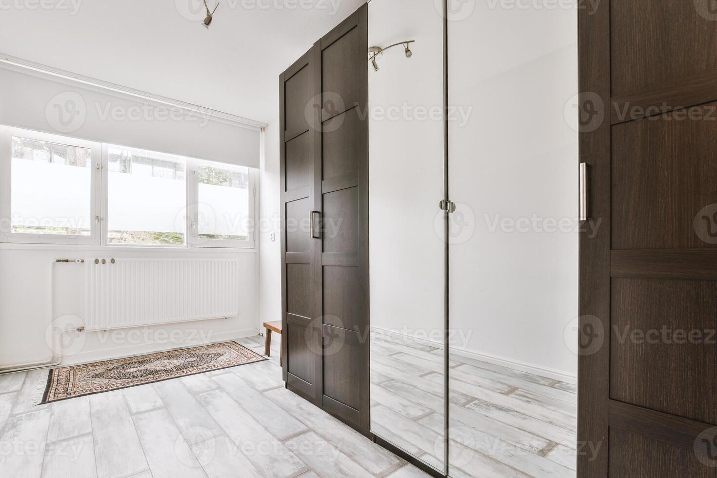 A room with a mirror and a wooden closet photo