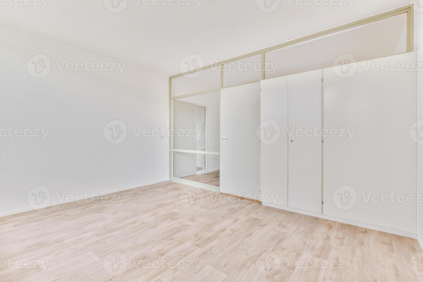 An empty room with white walls and wooden floors photo