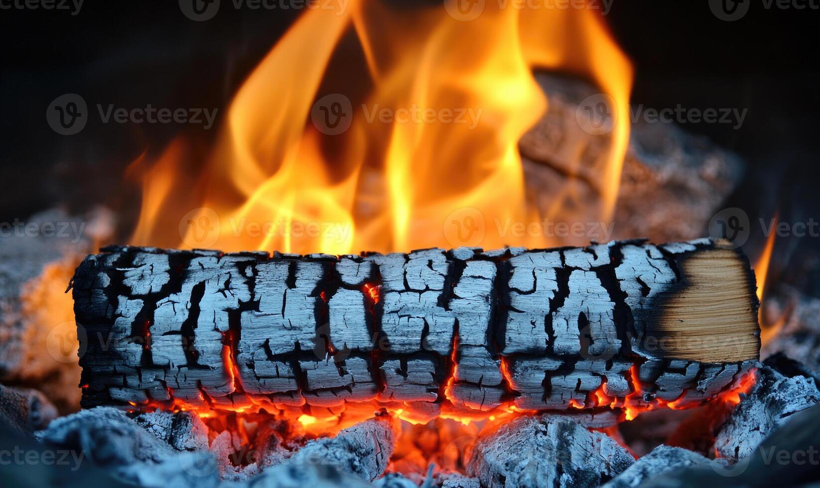 A burning log in an outdoor firepit, orange flames flickering photo