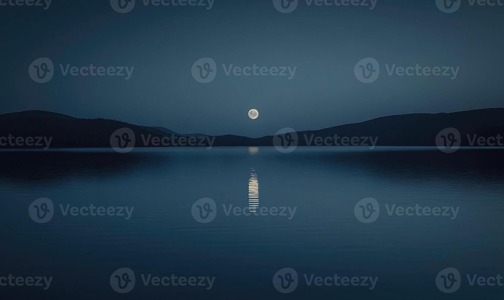 Bright full moon reflected in a still lake, distant hills barely visible in the darkness photo