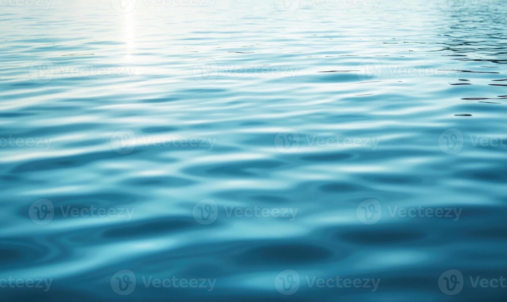 Calm lake surface with subtle waves, sunlight casting shimmering reflections photo