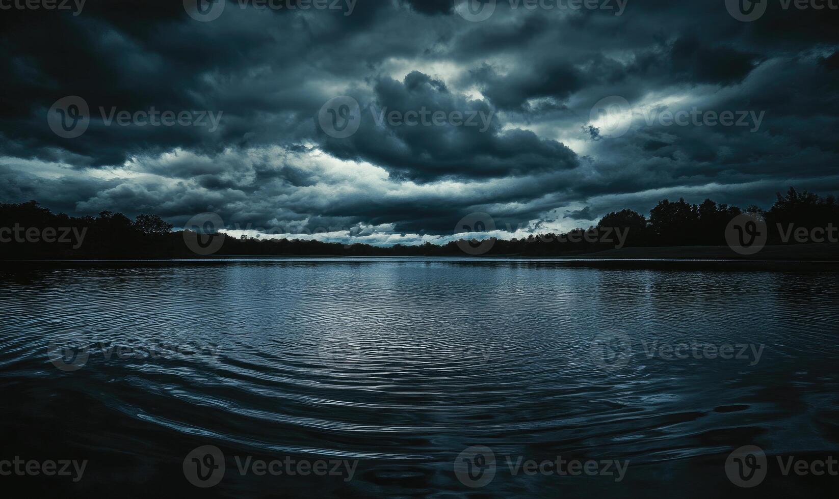 Dark and brooding clouds gathering over a quiet lake photo