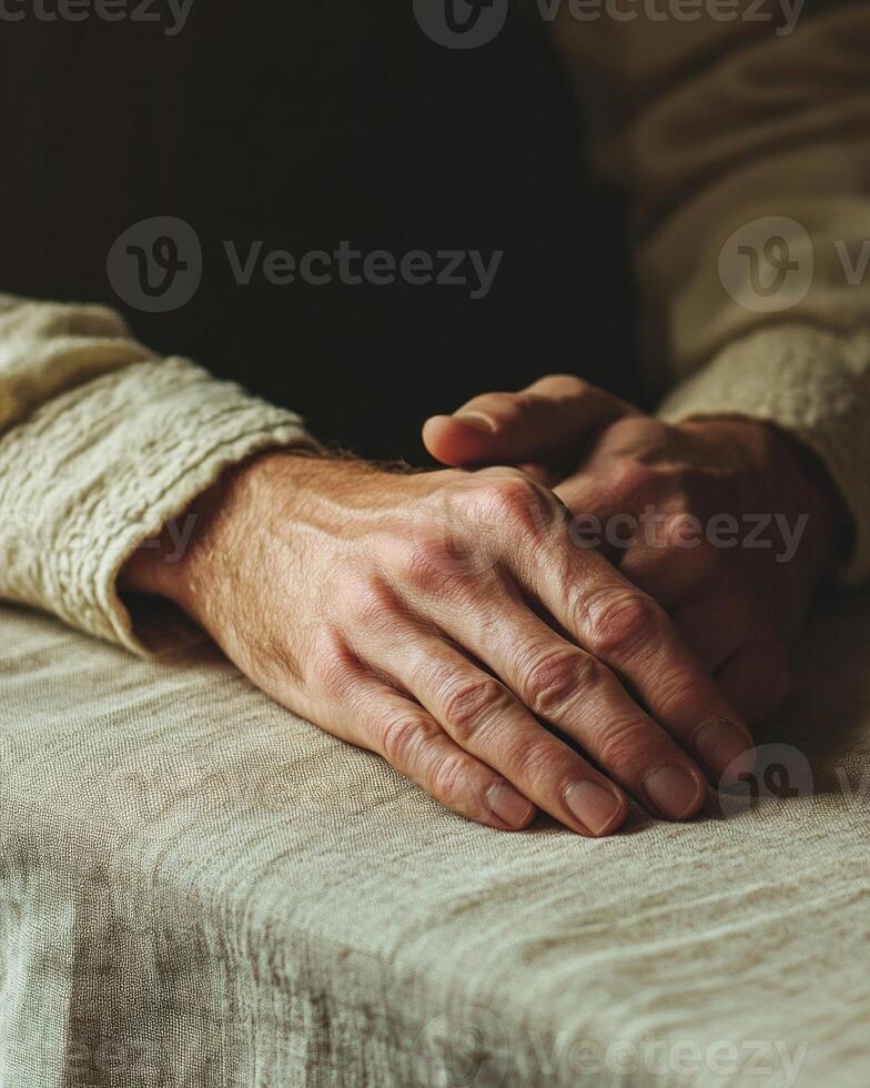 A man's hands are resting on a table, and the image conveys a sense of comfort photo