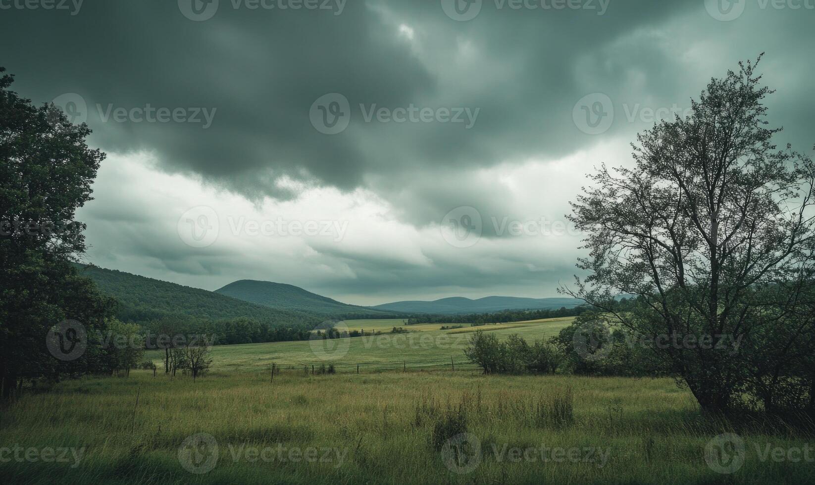 Overcast sky looming above a quiet countryside, thick gray clouds covering the entire sky photo