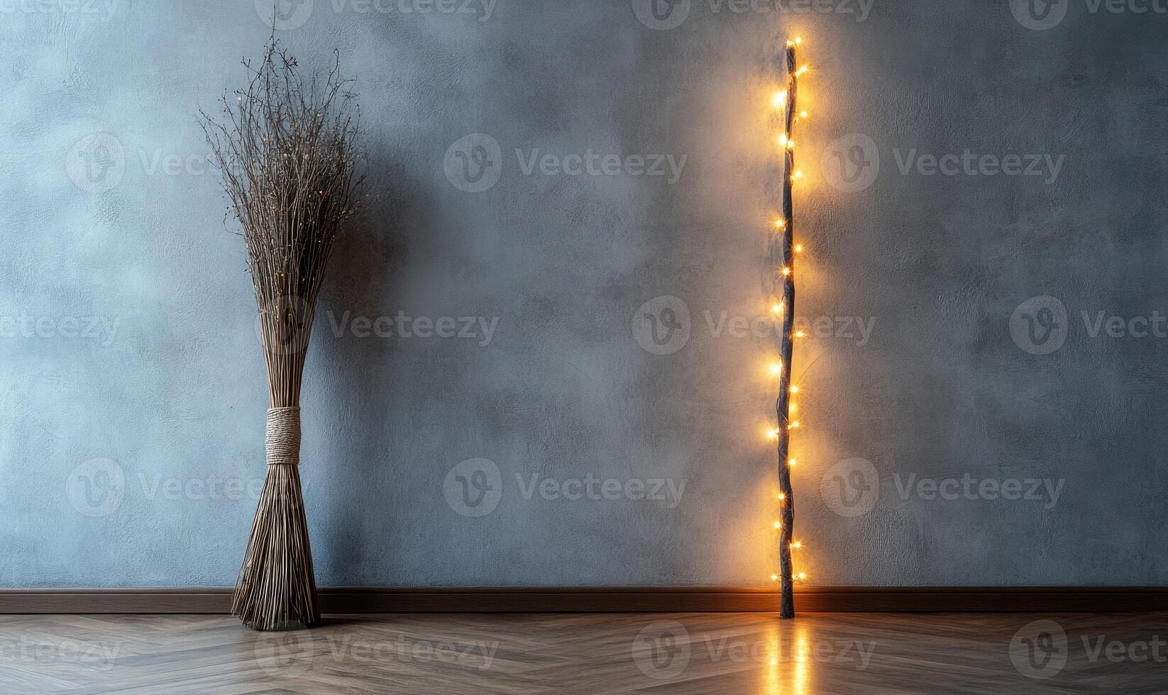 Elegant witch's broom wrapped in fairy lights, standing upright against a smooth gray wall photo