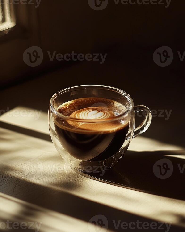 Glass cup filled with dark coffee, soft reflections on the glass photo