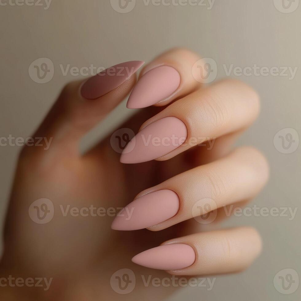 A hand holding a pair of long, pointed, pink nails photo