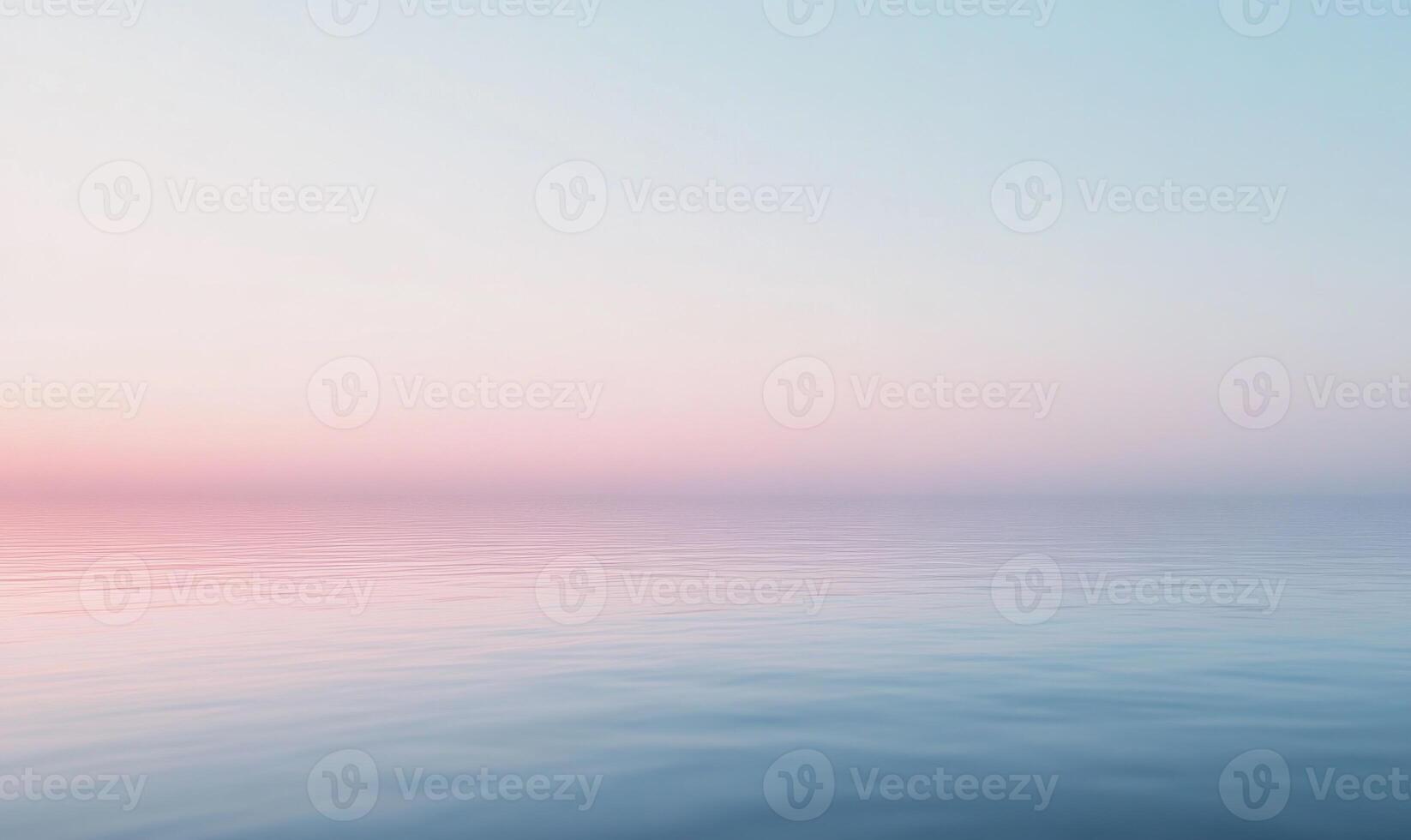 A calm ocean with a pink and blue sky in the background photo