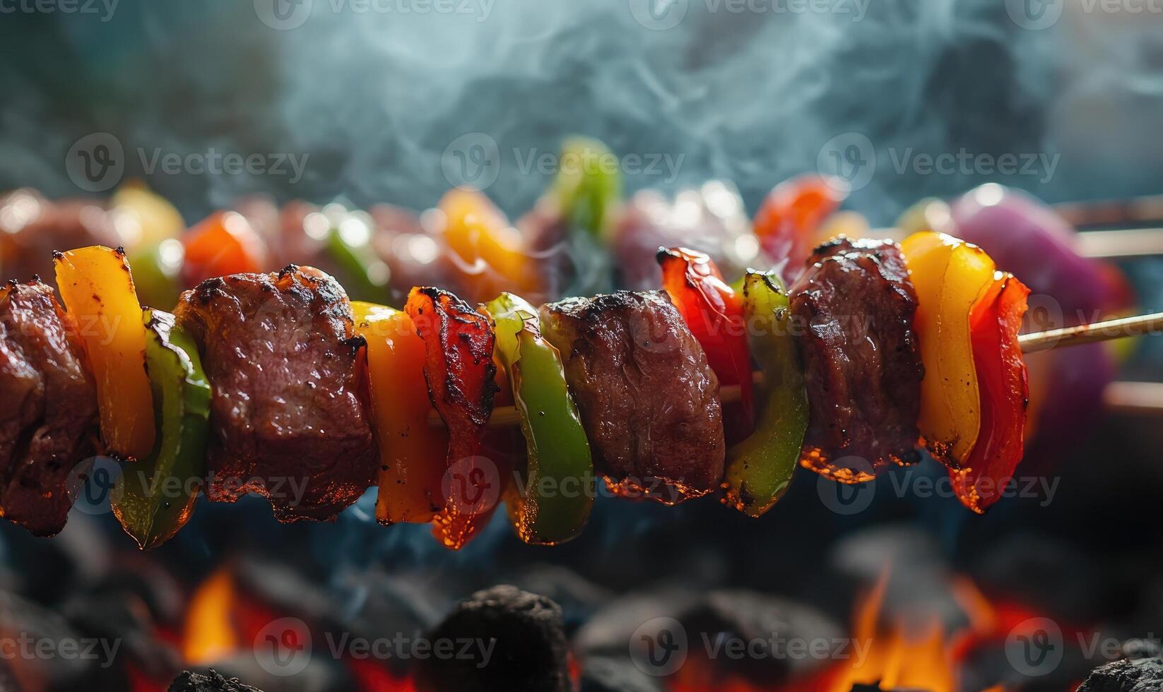 Skewers of colorful peppers and onions grilling over hot coals photo