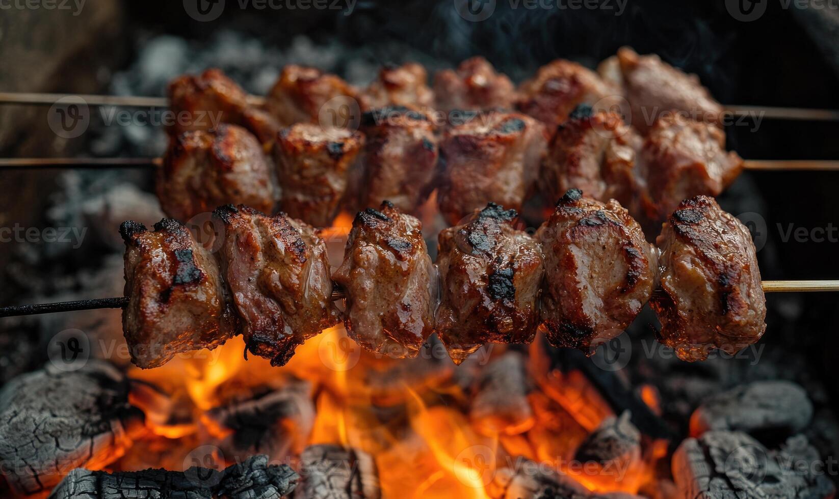 Meat grilling over a bed of red-hot coals photo