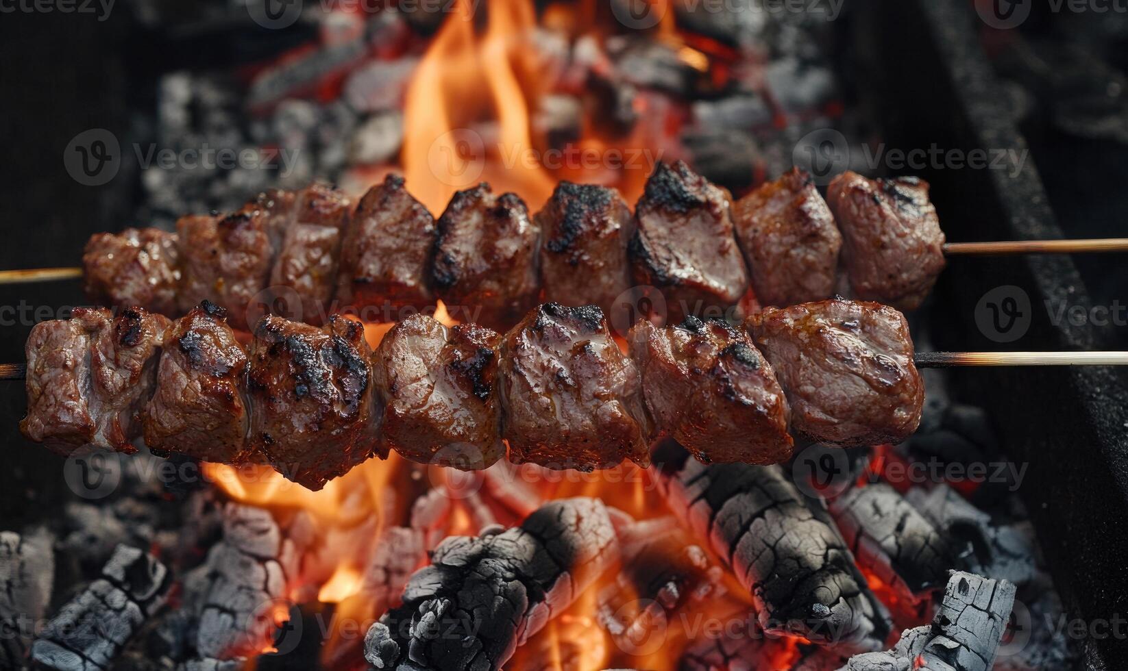Meat grilling over a bed of red-hot coals photo