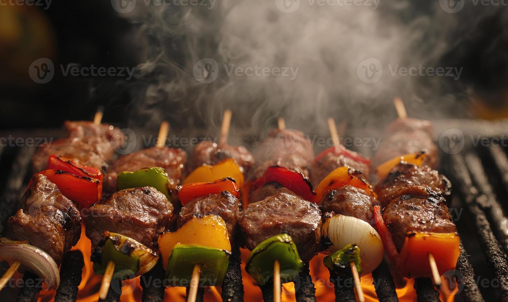 Skewers of colorful peppers and onions grilling over hot coals photo