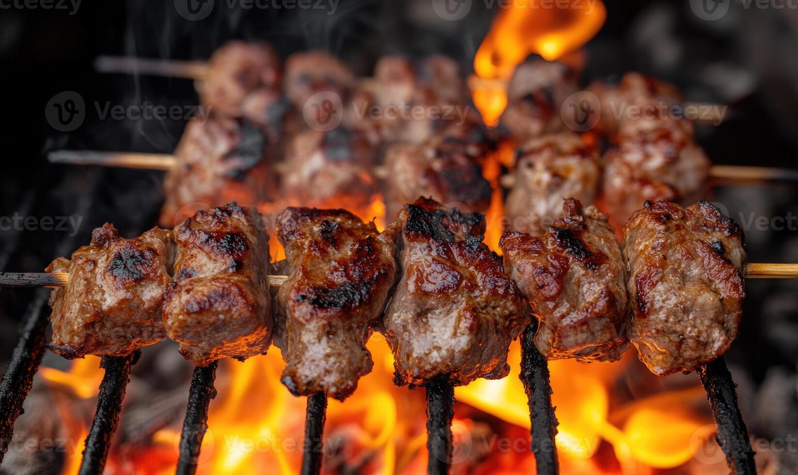 Skewers of lamb shashlik slowly turning over smoldering coals photo