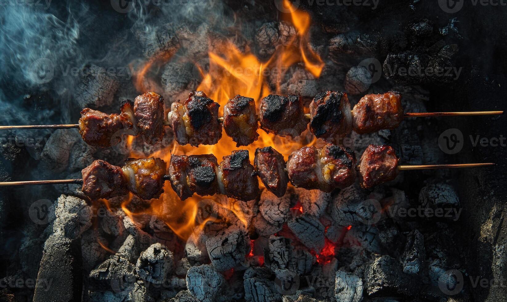 Skewers of lamb shashlik slowly turning over smoldering coals photo