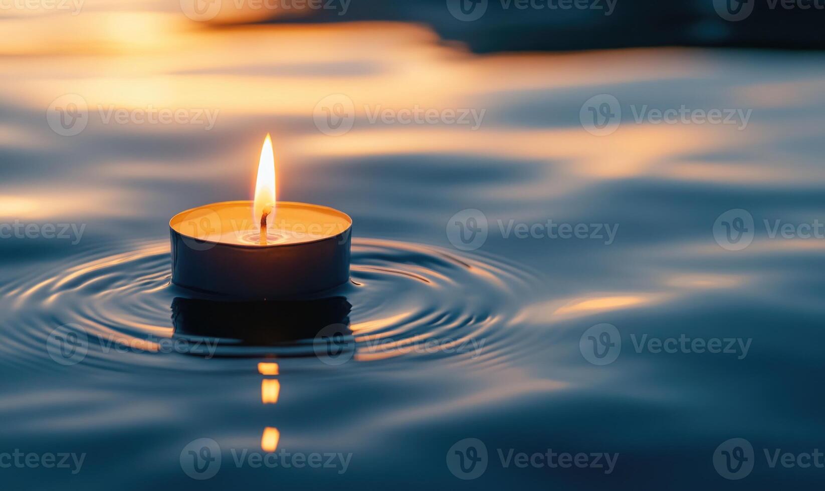 Single candle drifting softly on a calm lake, warm glow reflecting off the water photo