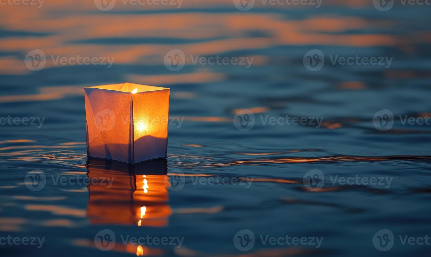 Single floating candle on rippling water, soft golden glow illuminating the scene photo