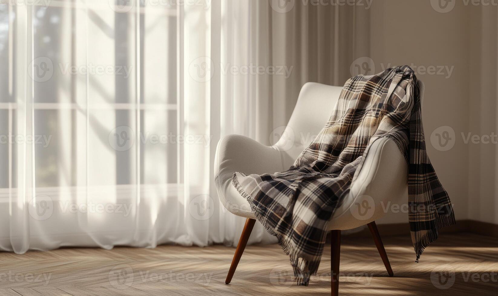 A white chair with a plaid blanket draped over it sits in front of a window photo