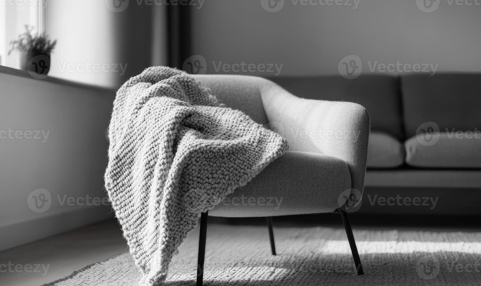 A black and white photo of a chair with a blanket