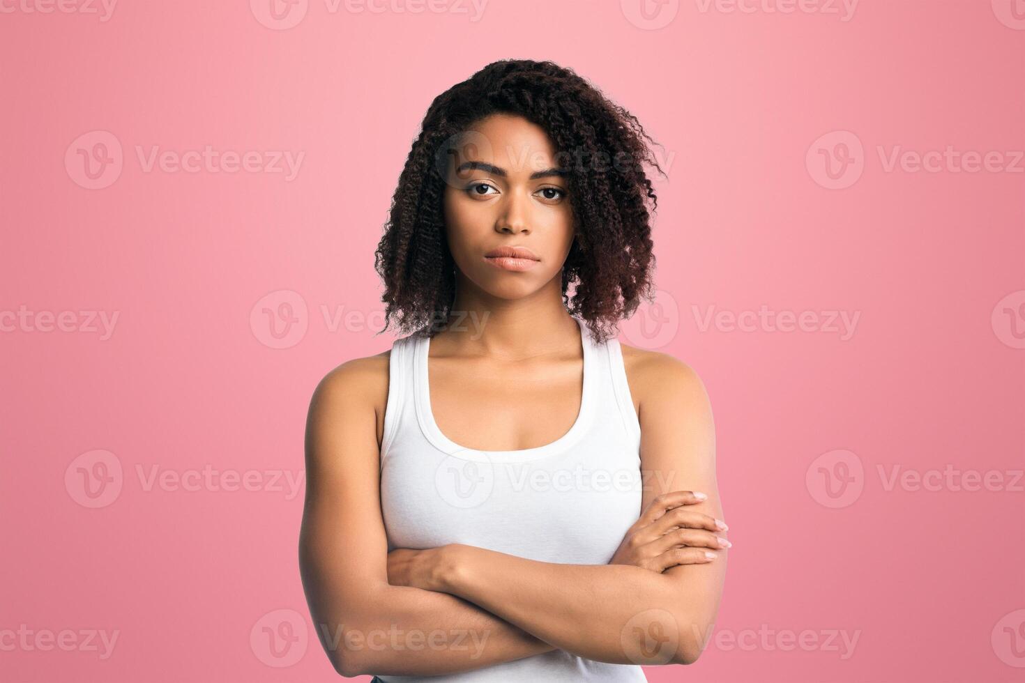 Bad Attitude. Portrait of serious black woman standing with arms folded on white background, free space photo