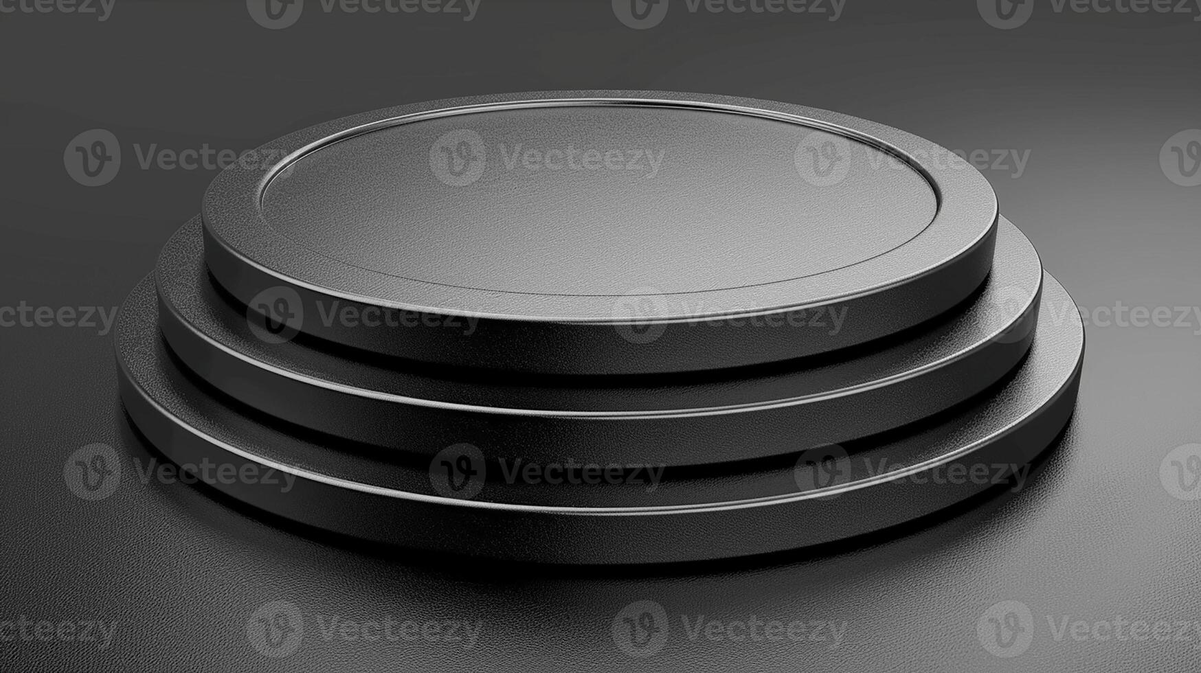 A stack of three black metal plates on a black surface photo