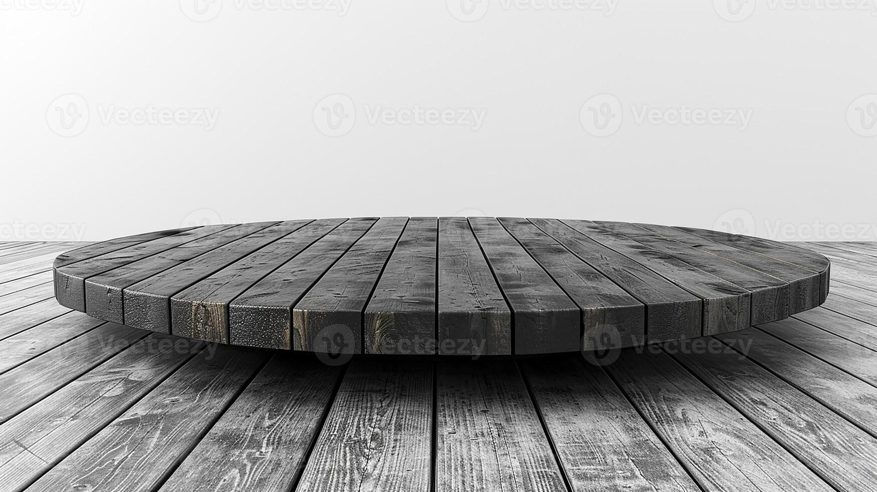 A black and white photo of a circular table on a wooden floor