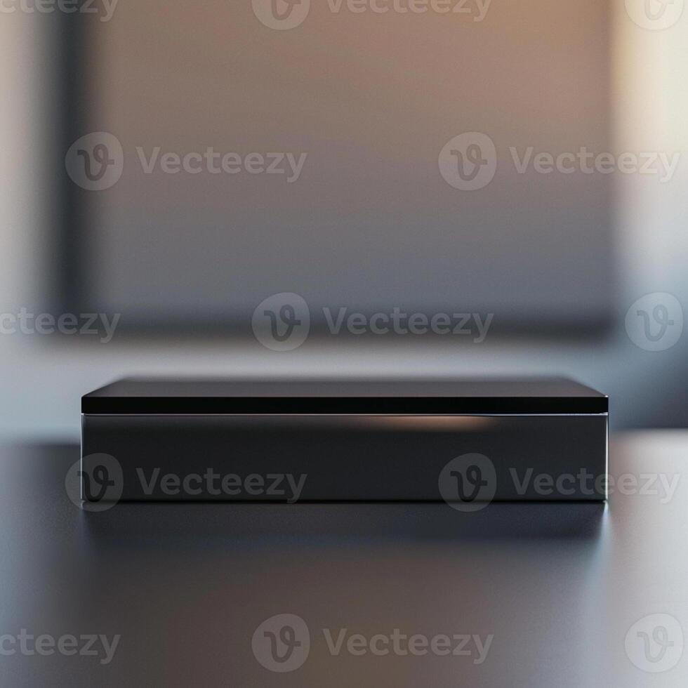 A black box sitting on a table in front of a blank wall photo