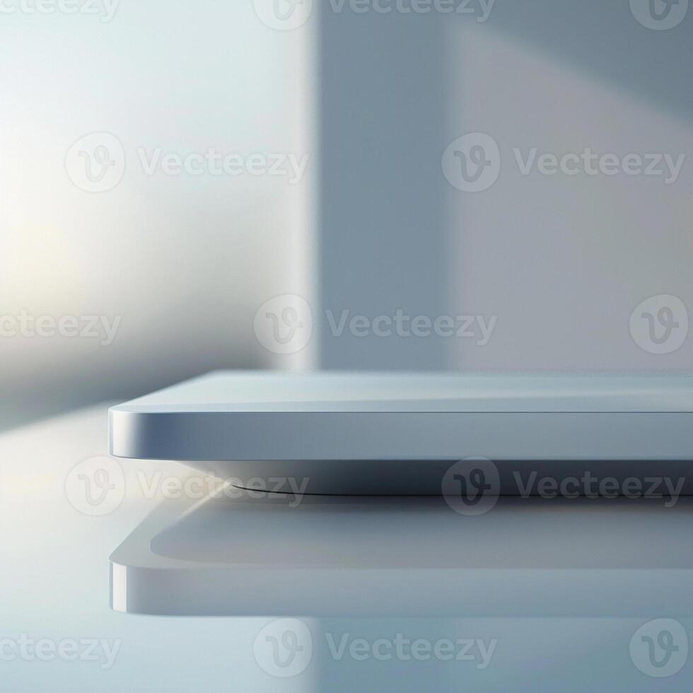 A white tablet sitting on a table with a window in the background photo
