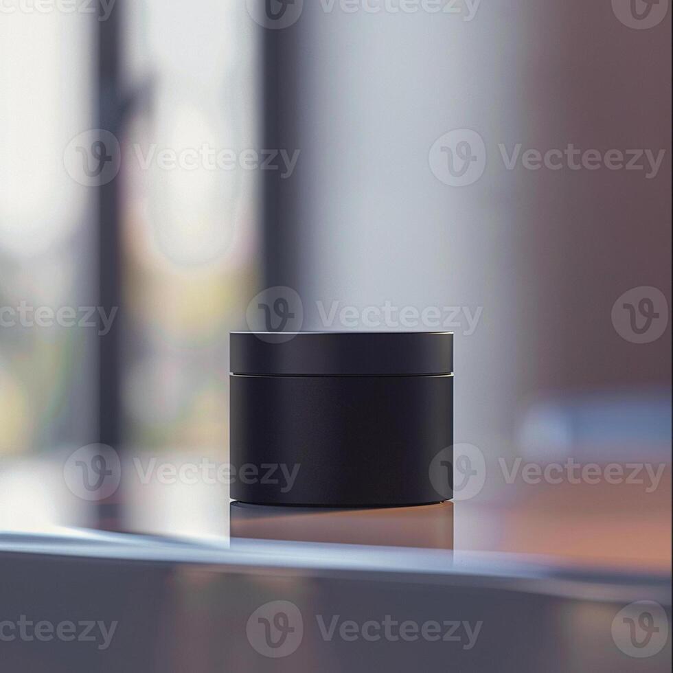 A black container sitting on a table in front of a window photo