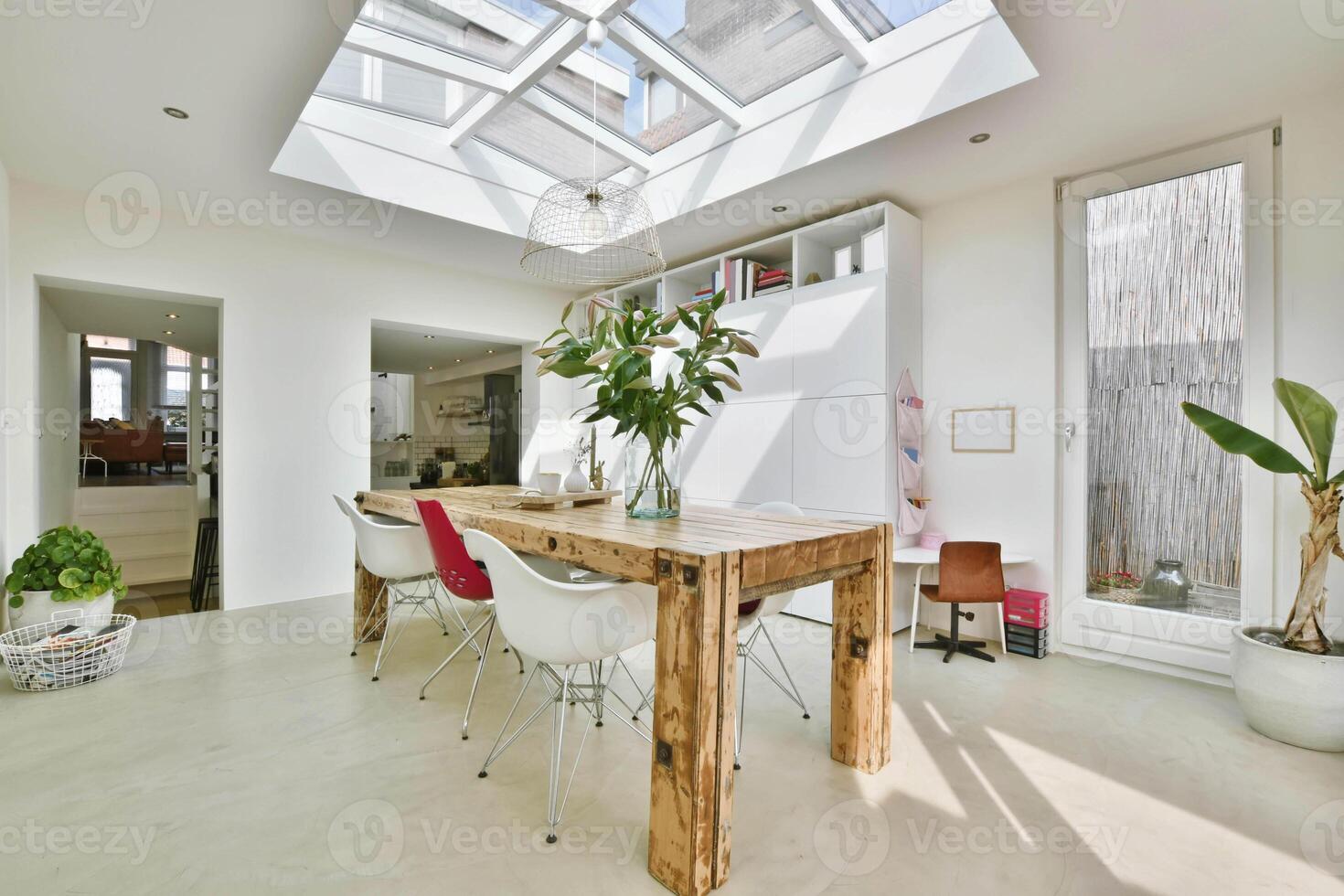 A modern kitchen with skylights and a table photo
