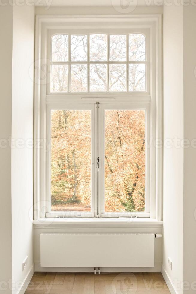 A white room with a window and a radiator photo